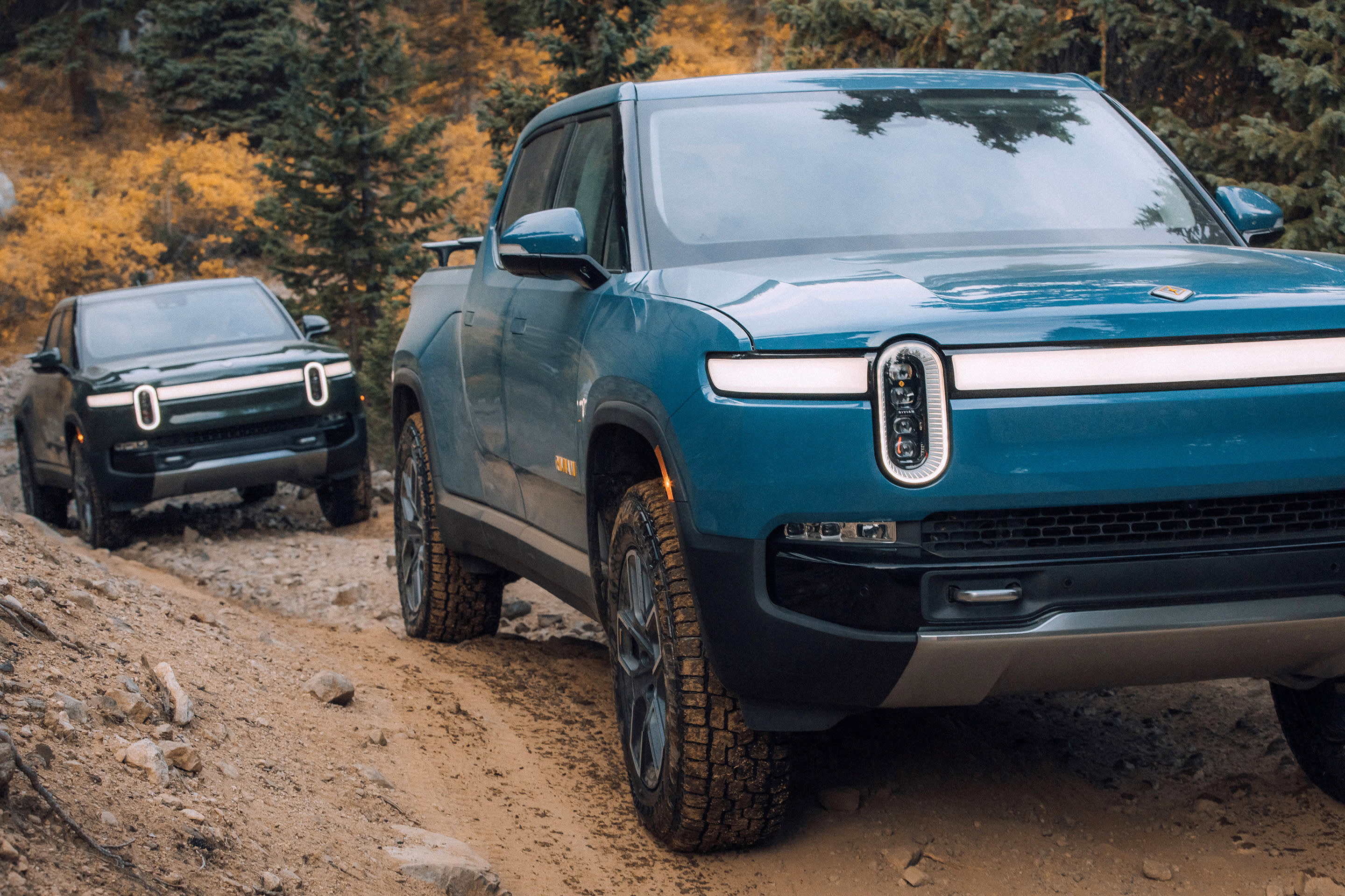 Rivian 1T offroading on a rocky dirt road.