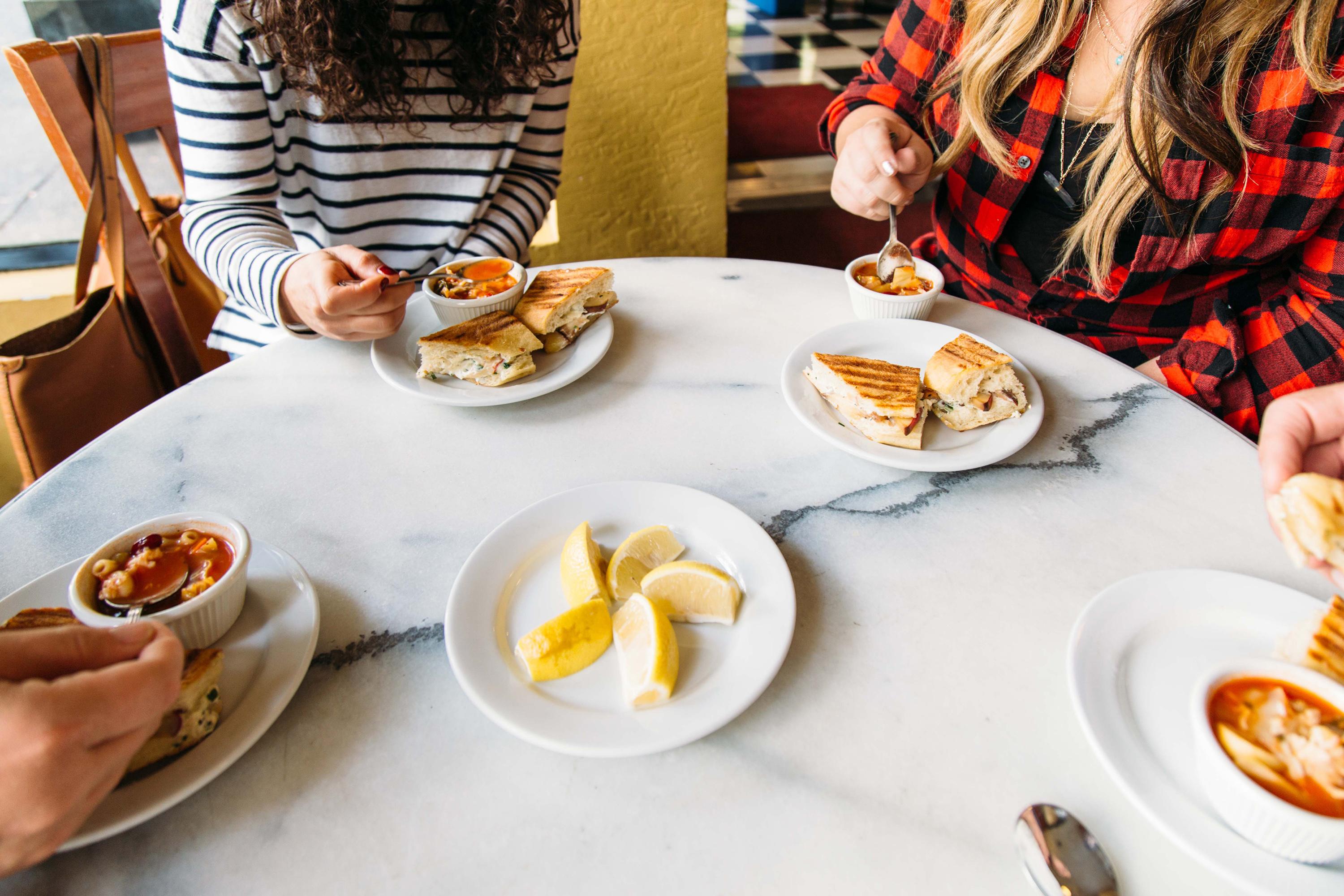 A group of friends at sandwiches and soup on a food tour in Sacramento, California