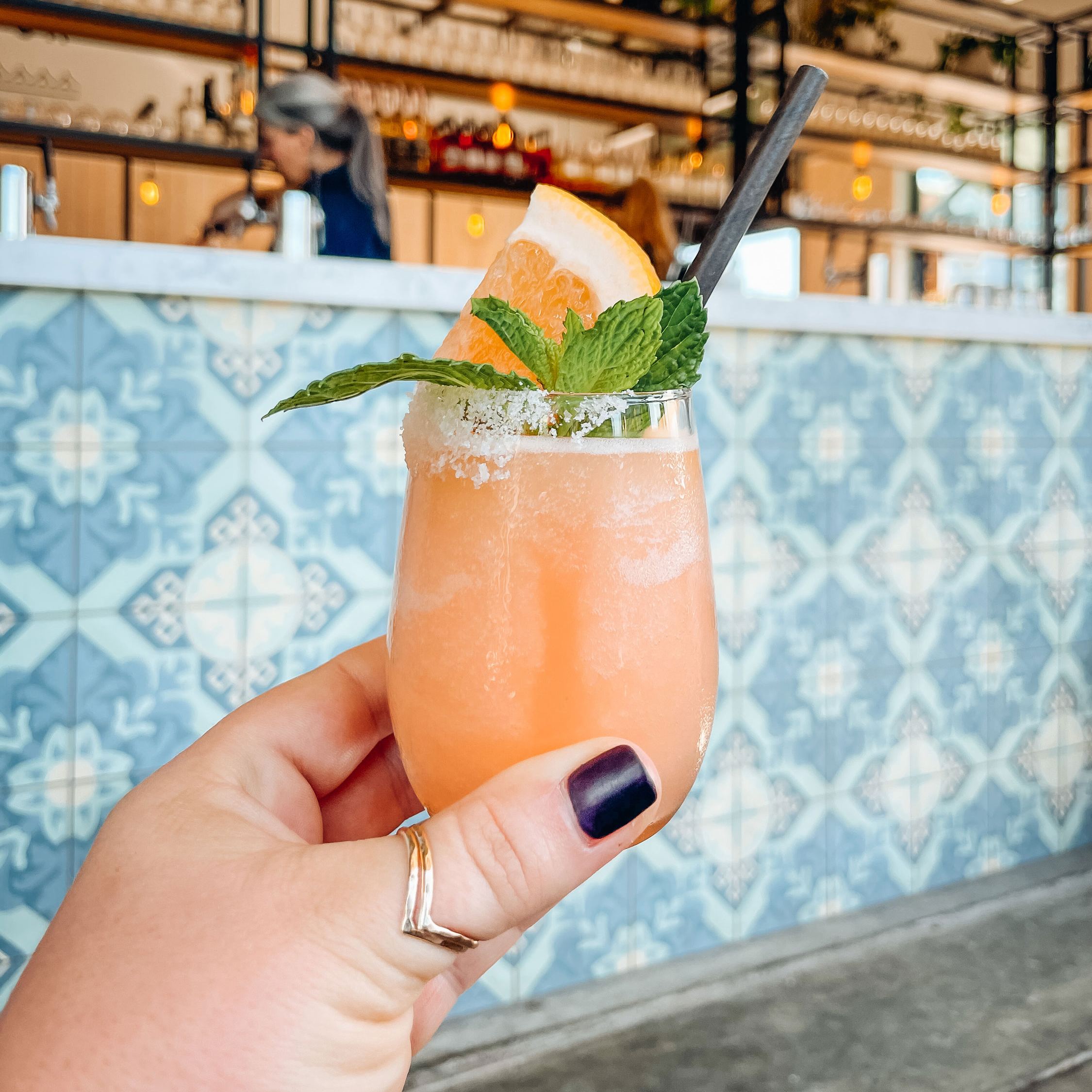 A hand holds out a mini frozen paloma libre from Venus Spirits Cocktails & Kitchen Westside.