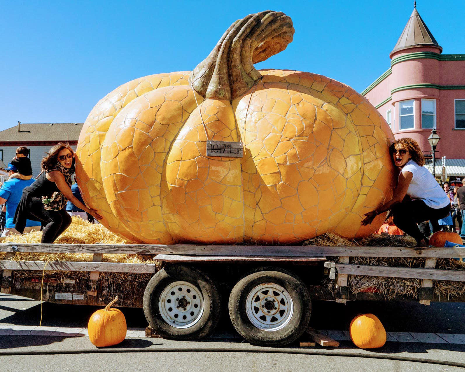 Two women pose with a pumpkin sculpture at the Half Moon Bay Art and Pumpkin Festival on California's coast.