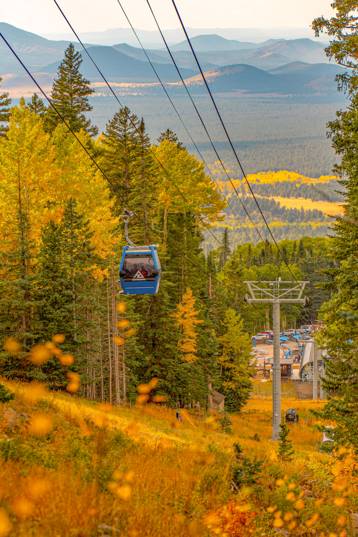 A gondola goes up the hill at Arizona Snowbowl with fall color in the background.