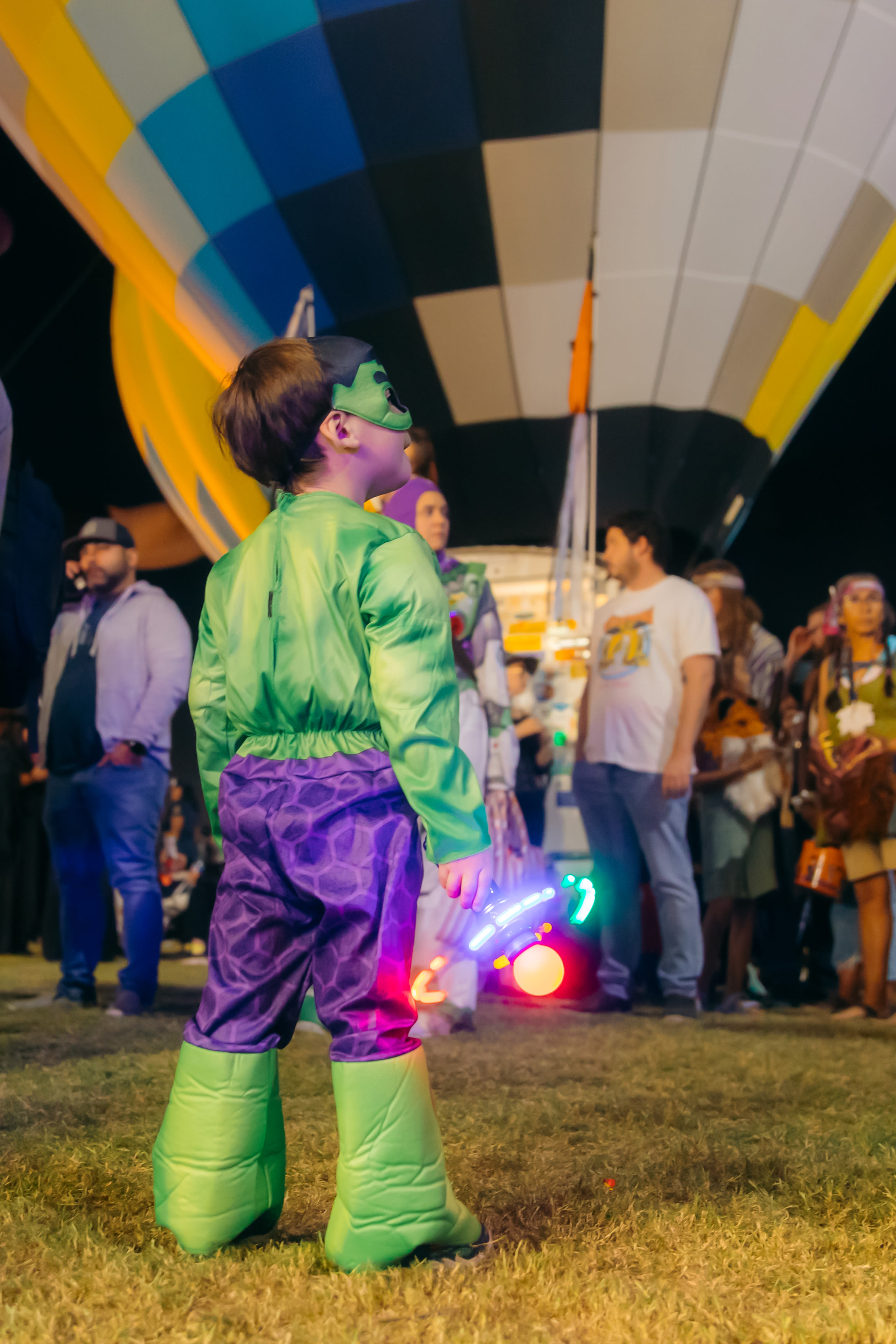 A child dressed as the Hulk stares up at a hot air balloon at the Spooktacular Hot Air Balloon Festival in Scottsdale, Arizona.