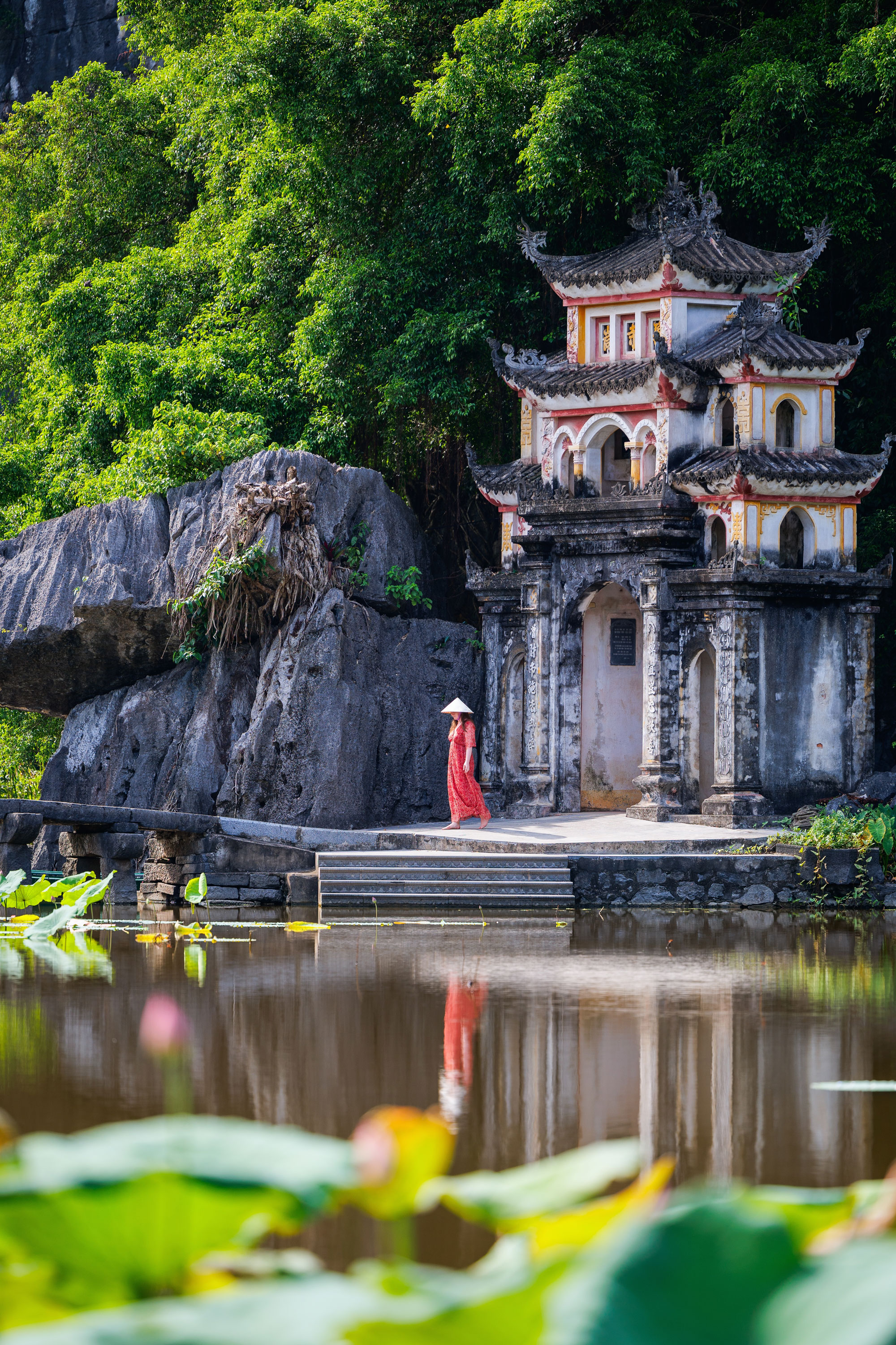 A woman stands in front of the Bich Dong pagoda in Ninh Binh, Vietnam.