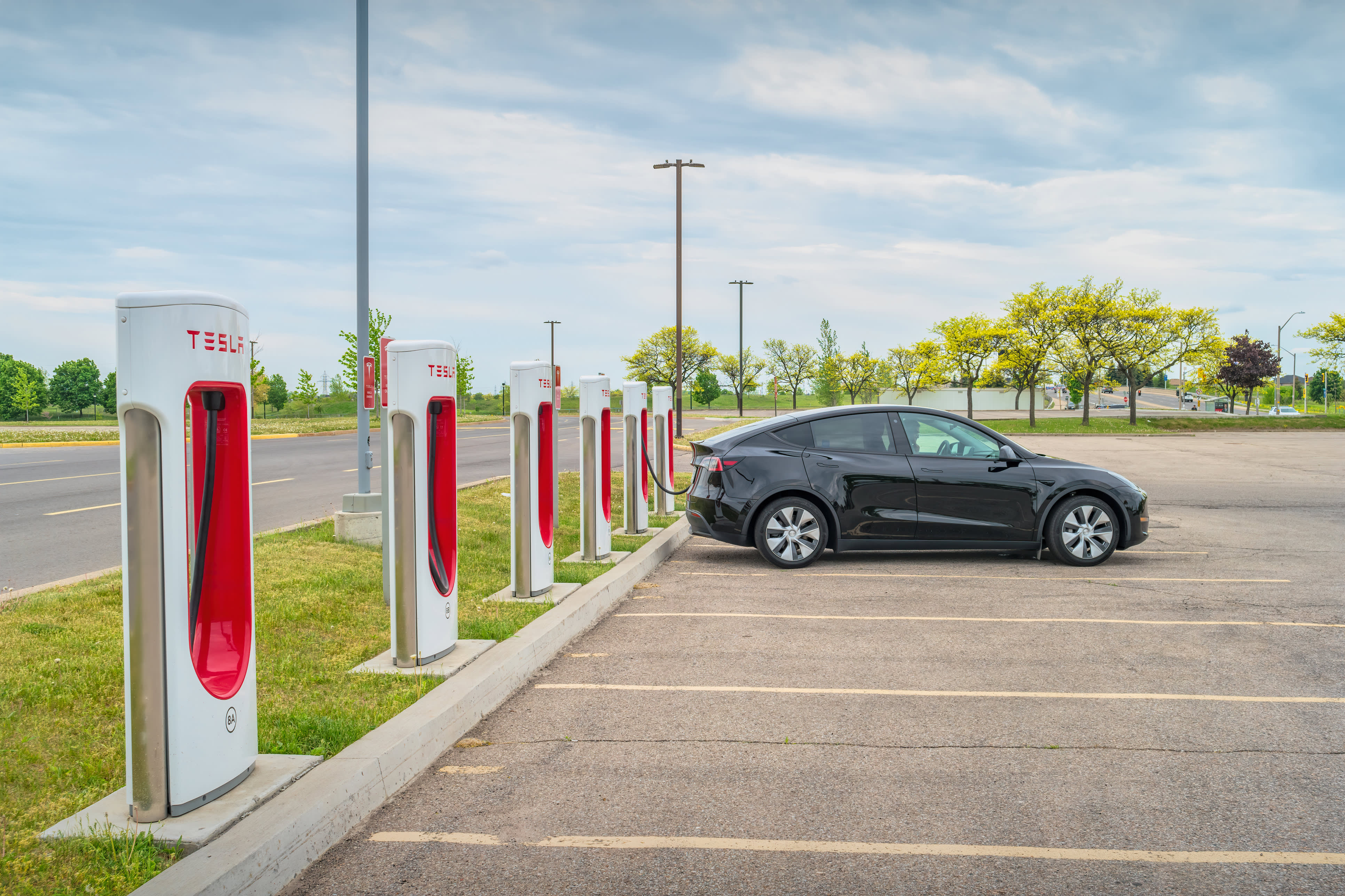 Black Tesla Model Y parked at a Supercharger.