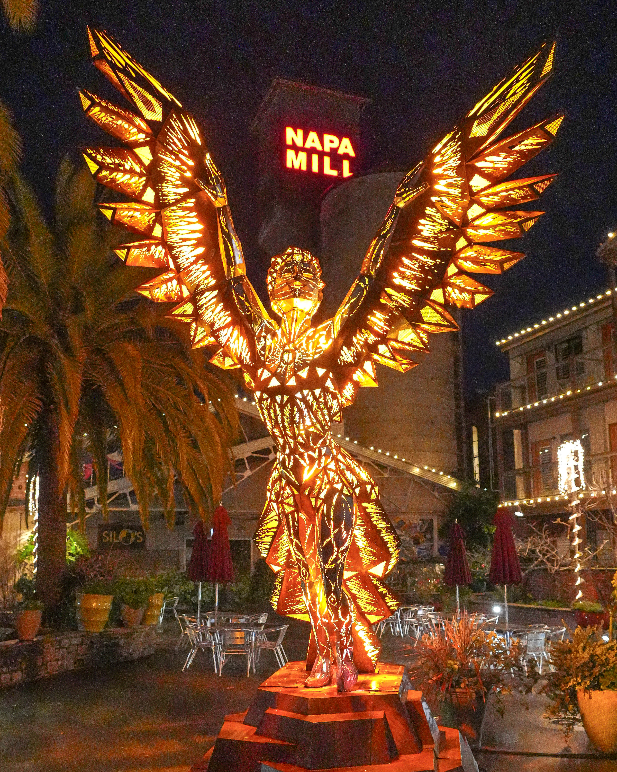 An installation from the Napa Lighted Art Festival in Napa, California with the Napa Mill in the background.