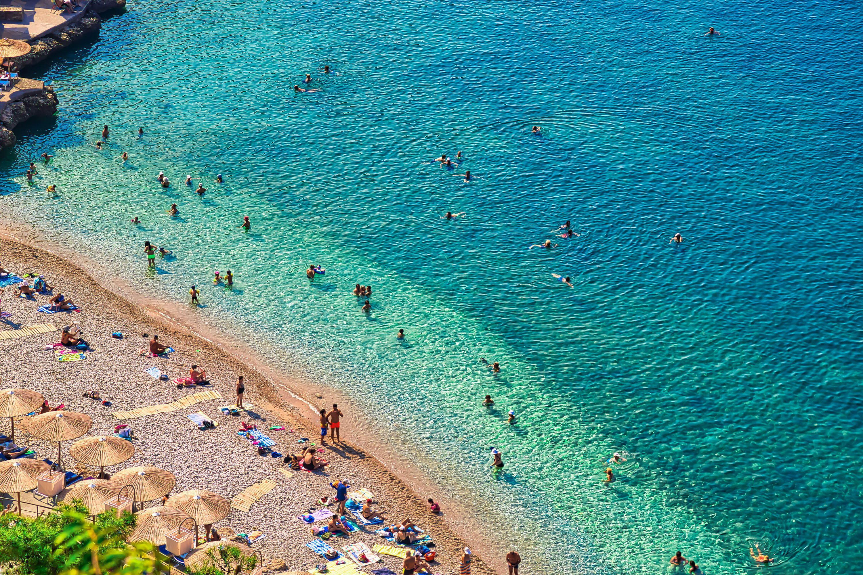 People relax on Arvanitia beach in Nafplio, Greece.