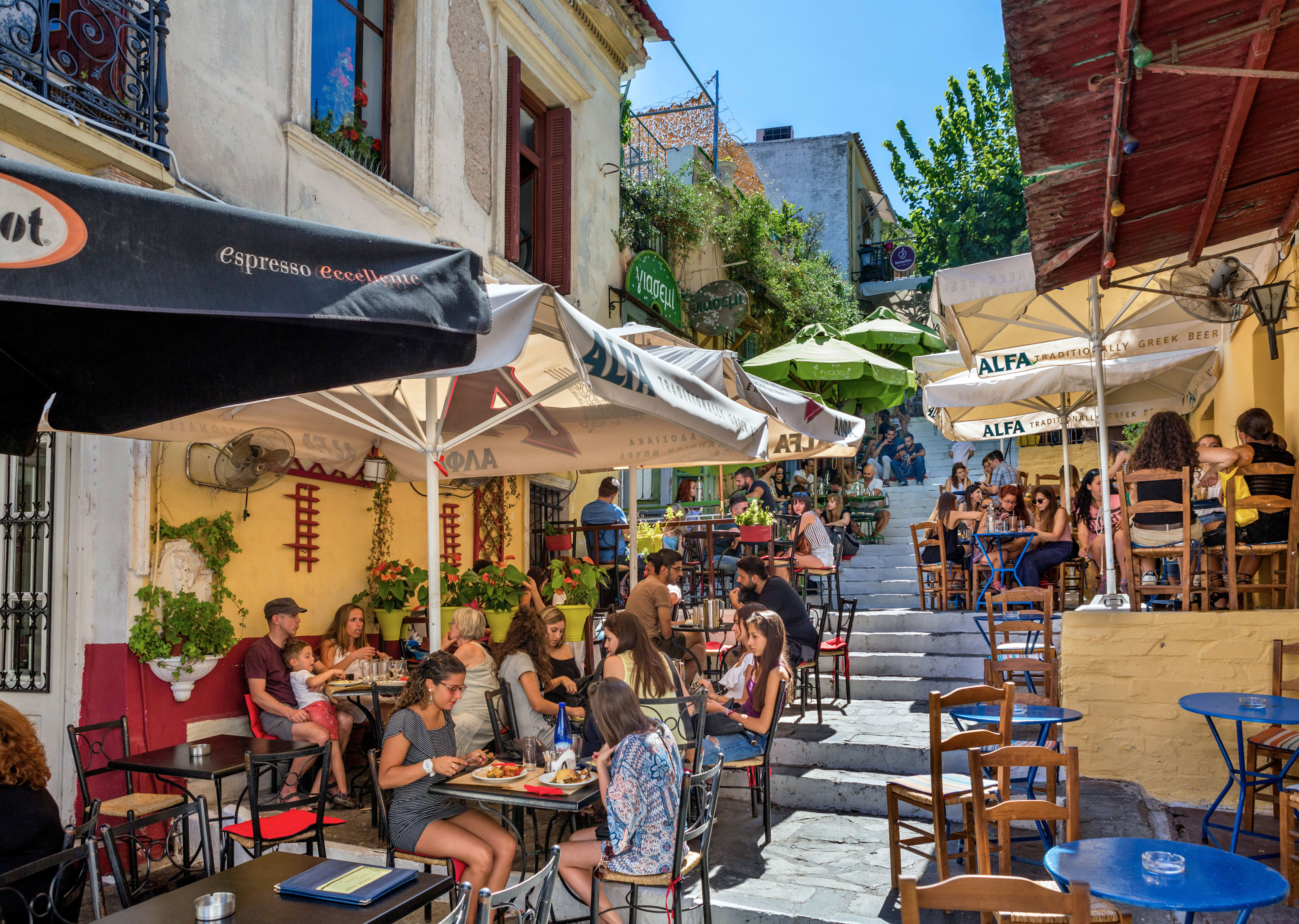 Visitors sit at outdoor tables at the cafes and tavernas on Mnisikleous Street in the Plaka district, Athens.