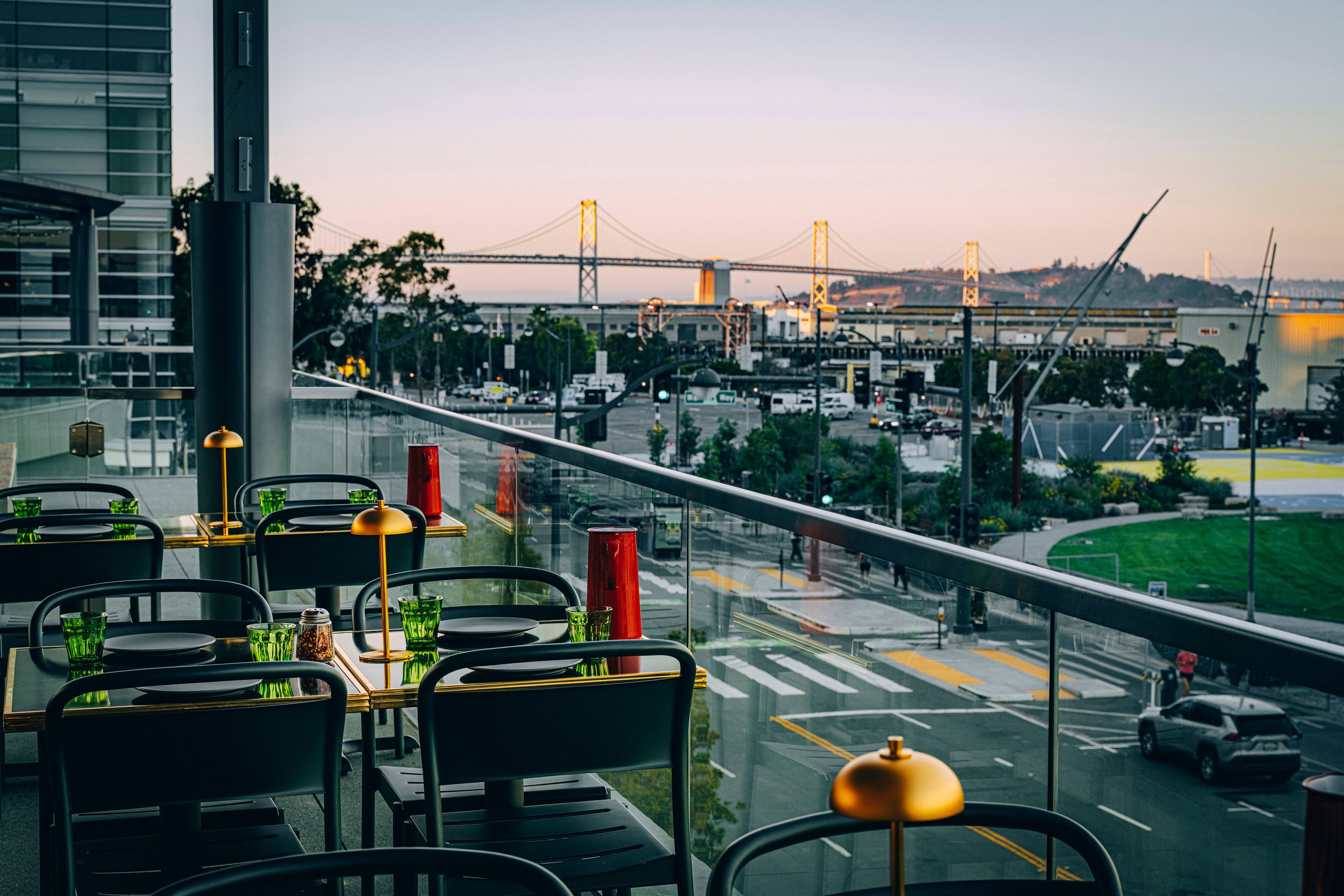 a hip patio at a restaurant with a view of the San Francisco Bay Bridge